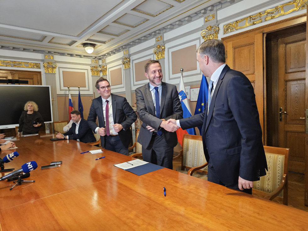 Podpredsednik Združenja mestnih občin Slovenije Samo Turel, minister Klemen Boštjančič in predsednik Skupnosti občin Slovenije Gregor Macedoni se rokujejo po podpisu dogovora