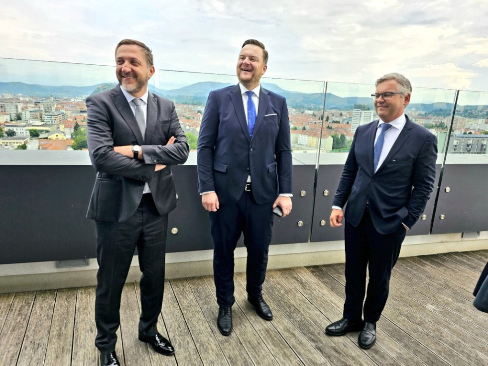 Ministri stoji na balkonu, v ozadju se vidi Gradec