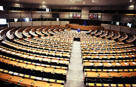 Evropski parlament_prazna dvorana (An empty hall of the European Parliament, where tables and chairs are lined up one after the other in a circle.)