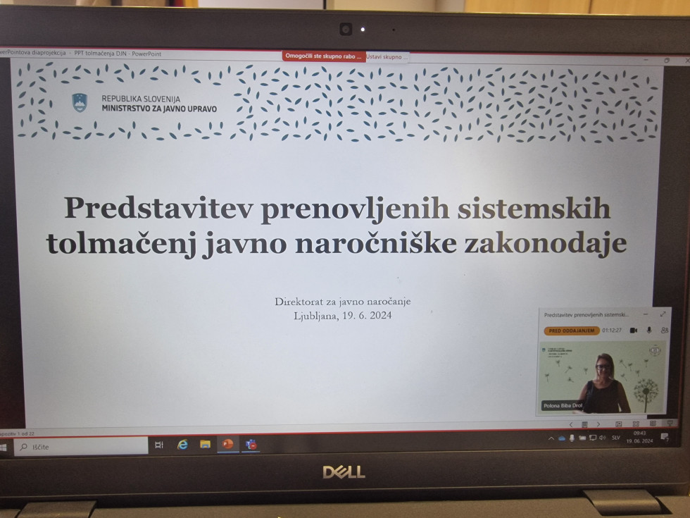 Na računalniškem ekranu je powerpoint prosojnica z naslovom Predstavitev prenovljenih sistemskih tolmačenj javno naročniške zakonodaje