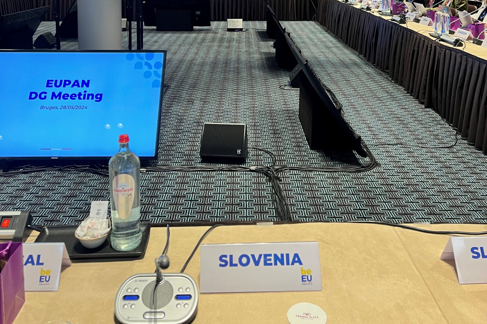 Slovenska delegacija  na srečanju EUPAN sedi za mizo na kateri sta napis "SLOVENIA" in mikrofon