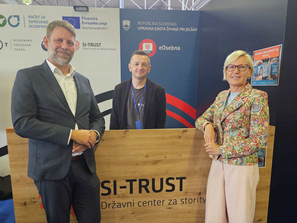 Državni sekretar Jure Trbič in načelnica Upravne enote Šmarje pri Jelšah mag. Jasna Junkar in zaposleni iz upravne enote stojijo pri SI_TRUST stojnici