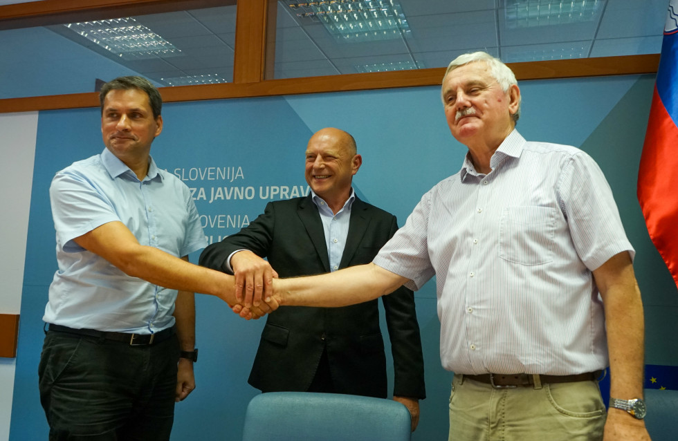 Minister mag. Franc Props in sindikalista Frančišek Verk ter Dragan Stanković se rokujejo