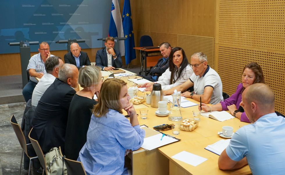 Vodja službe za UE, minister in državni sekretar sedijo za mizo kjer imajo sestanek z načelniki upravnih enot