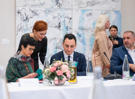 The Minister of Culture and the European Commissioner during a chat, the Minister standing and bowing to the European Commissioners