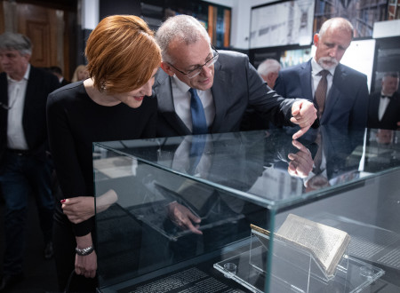Ministrica in predsednik SAZU si ogledujeta razstavljeni Stiški rokopis