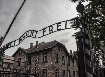 Oblačno vreme, v ozadju hiša v koncetracijskem taborišču Auschwitz, v ospredju napis Macht Frei