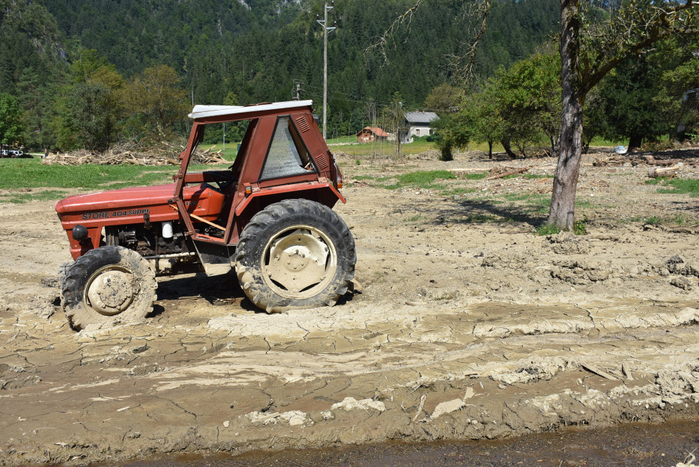 Pogled na poškodovan traktor na kmetijskem zemljišču. 