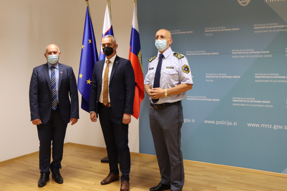 Državni sekretar dr. Božo Predalič, direktor črnogorske policije Zoran Brdjanin in generalni direktor policije dr. Anton Olaj stojijo pred zastavami