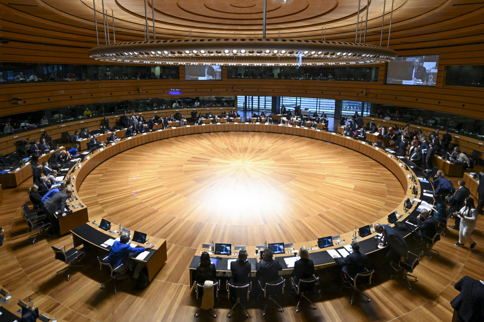 People sitting behind a big oval table