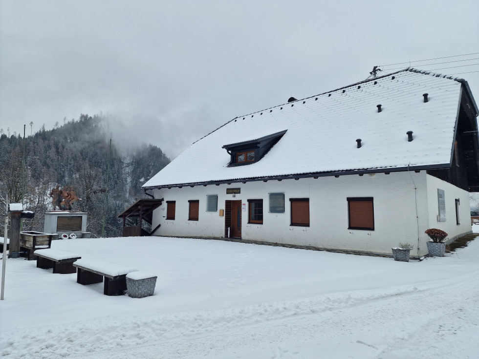 Zgradba muzeja in spomenik pred njo, pokrito s snegom.