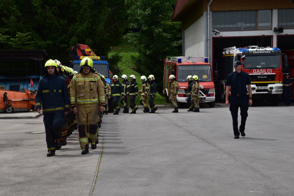 Novo usposobljeni gasilci so v gasilskih oblačilih postrojeni na ploščadi centra na Igu