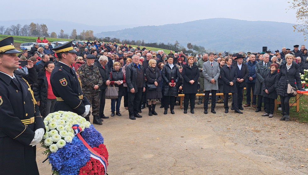 Minister in udeležnci slovesnosti na prostoru pred spomenikom. Ob strani sta gardista z vencem.