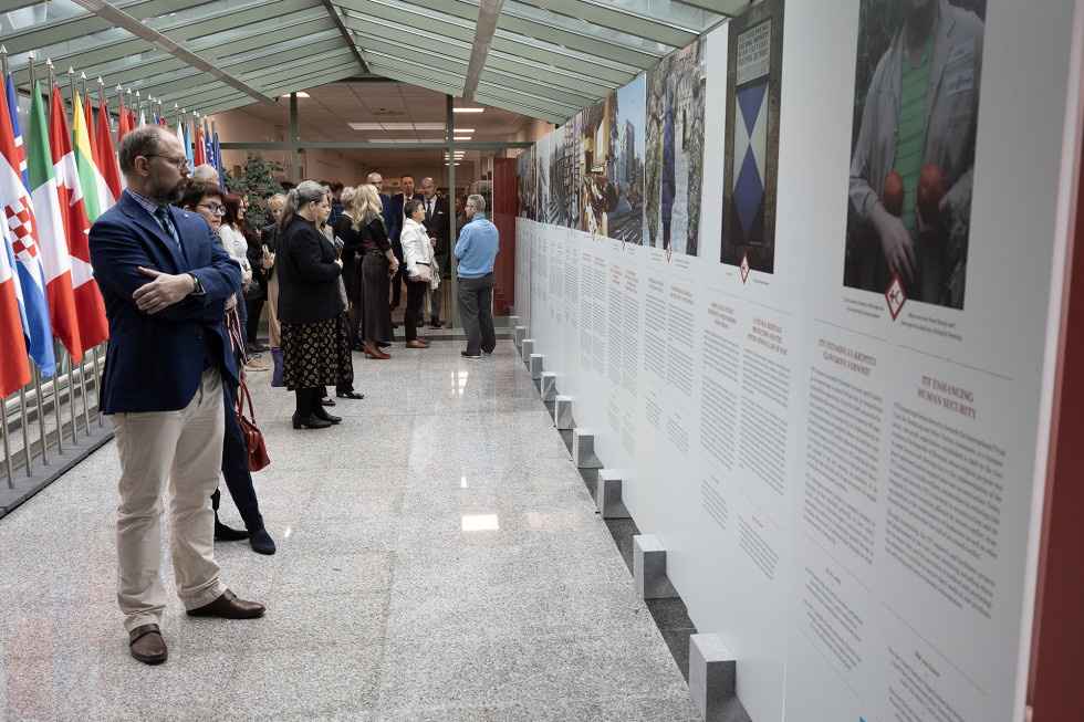 Obiskovalci razstave pred panoji z besedilom in fotografijami