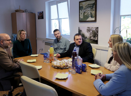 Sogovorniki sedijo za mizo in se pogovarjajo