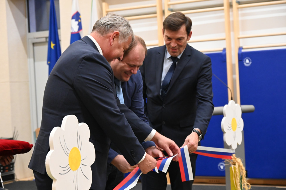 Minister dr. Vinko Logaj, župan Občine Sevnica in ravnatelj Osnovne šole Ane Gale režejo otvoritveni trak.  