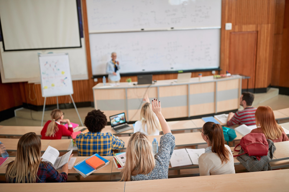 Študentke in študenti v predavalnici, v ozadju profesorica.