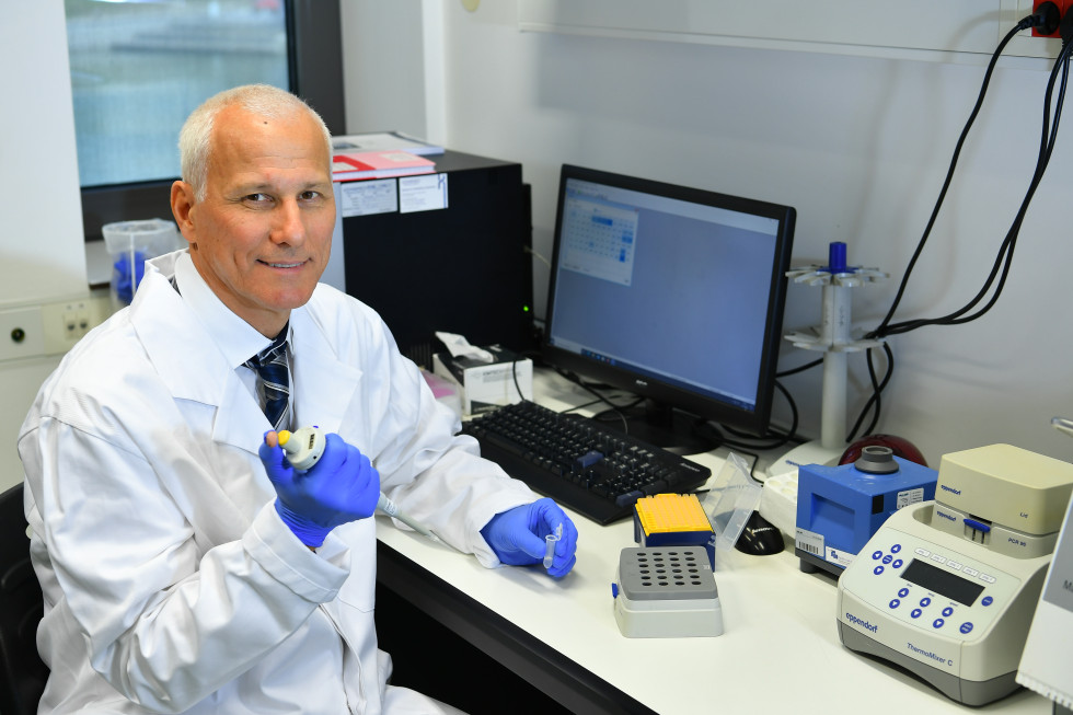 Dr. Potocnik with a pipette while sorting samples, in the background a desktop computer.