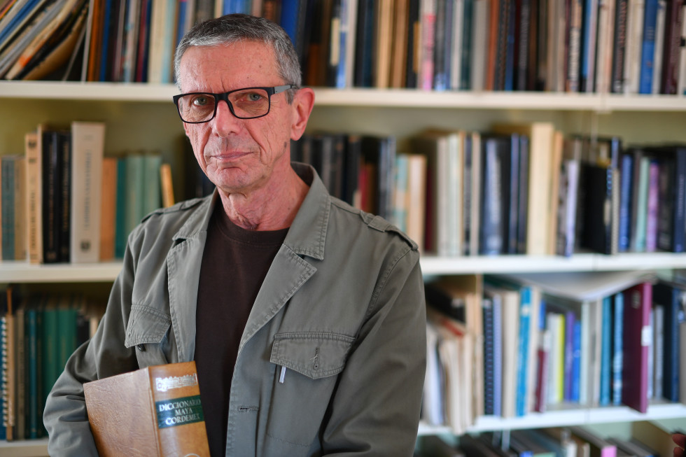 Portrait of Dr. Šprajc in front of the bookshelf.