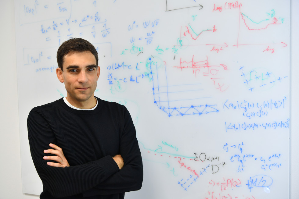 Dr. Vidmar in front of a blackboard with mathematical equations.