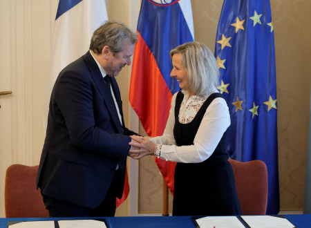 Minister za visoko šolstvo, znanost in inovacije dr. Igor Papič in njena ekscelenca, veleposlanica Francije Florence Lévy ob rokovanju po podpisu upravnega dogovora. V ozadju francoska, slovenska in evropska zastava.