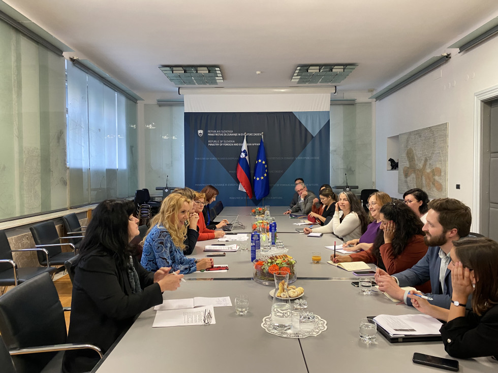 delegations sitting, taking, behind Slovenian and EU flag