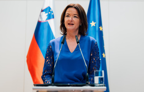 MinistricaTiskovka (minister speaking, behind flags)