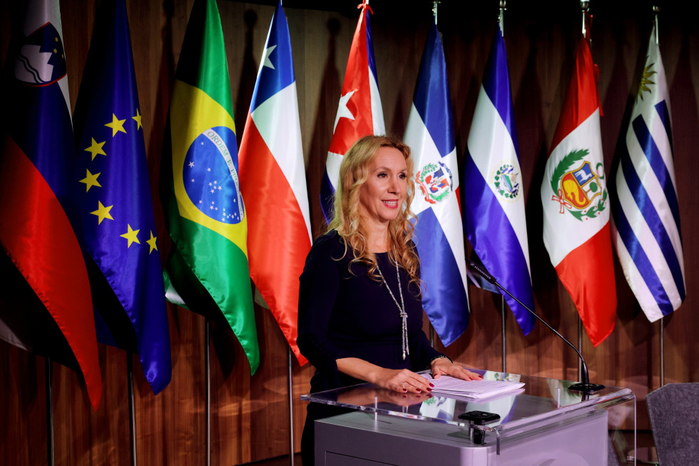 Stanković speaking on podium, behind her are flags