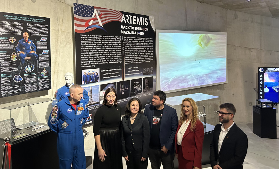 Predstavniki ministrstev in ameriške ambasade skupaj z astronavtom pod slikami in panojem z razstave