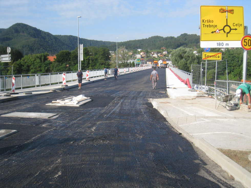 Pogled na most iz smeri Sevnice. Na mostu delavci. Položen prvi sloj asfalta.