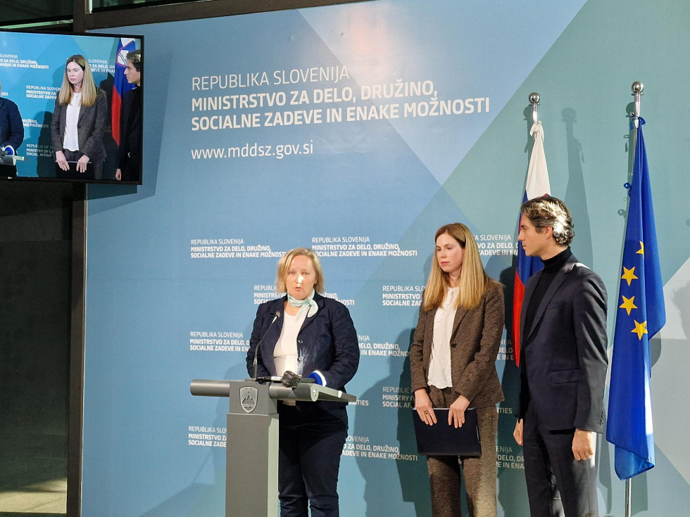 Nina Kurnik Avbelj, Katja Čoh-Kragolnik in Luka Mesec stojijo pred modrim ozadjem na novinarski konferenci