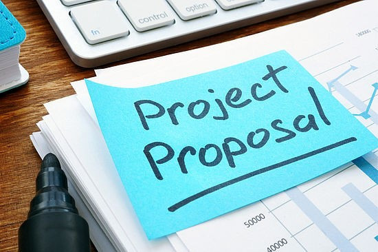 Uradna fotografija za razpis na kateri je tipkovnica z modrim listkom Project Proposal