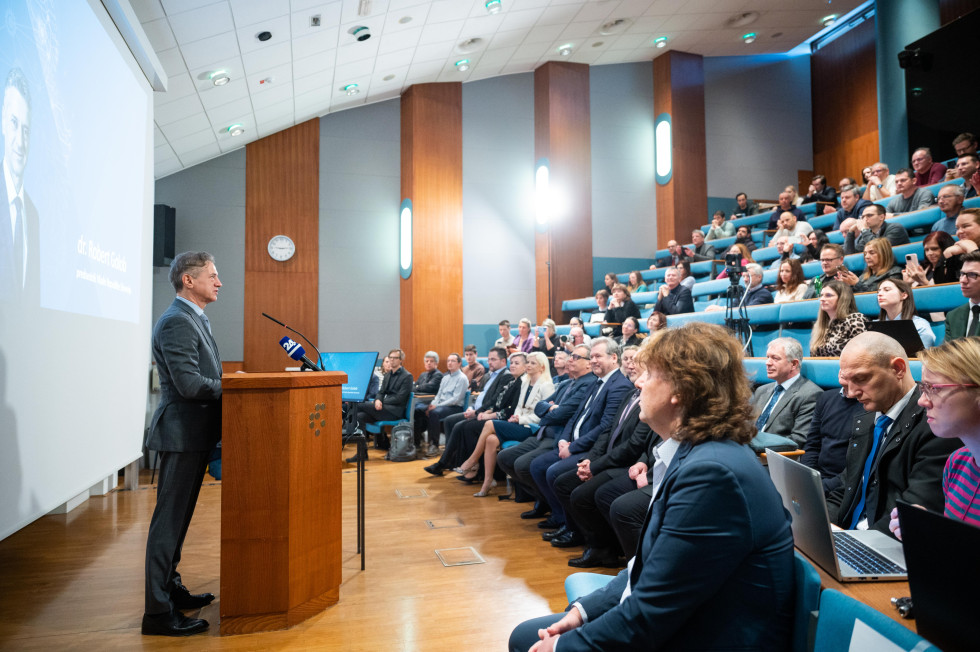 Predsednik vlade za govorniškim pultom in udeleženci