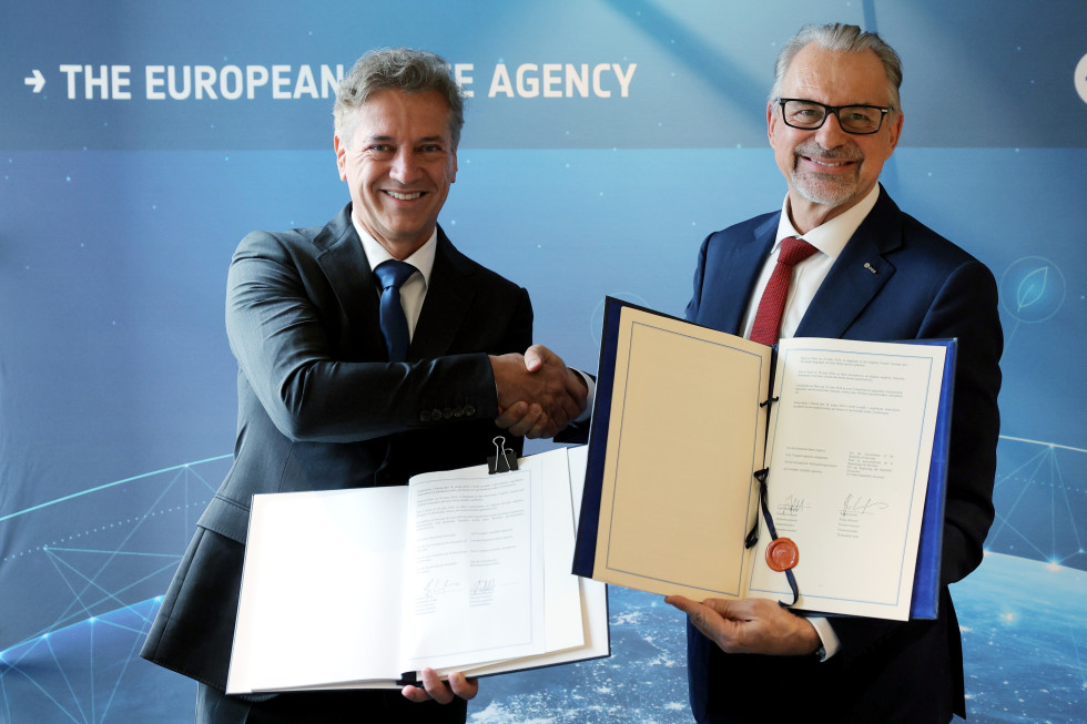 Predsednik vlade Robert Golob in generalni direktor Evropske vesoljske agencije (ESA) Josef Aschbacher se rokujeta ob podpisu sporazuma