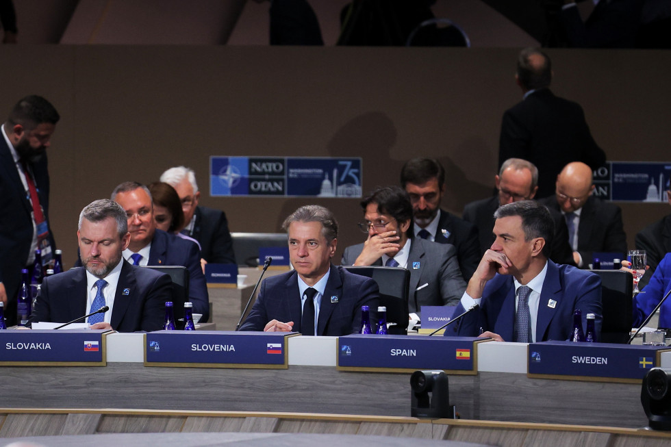 Predsednik vlade sedi za mizo med slovaškim in španskim premierjem