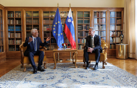 54118763343 0f3b2bbc48 c (Dr. Robert Golob and António Costa are seated and engaged in conversation. Behind them is a beautiful bookshelf, along with the Slovenian and European flags.)