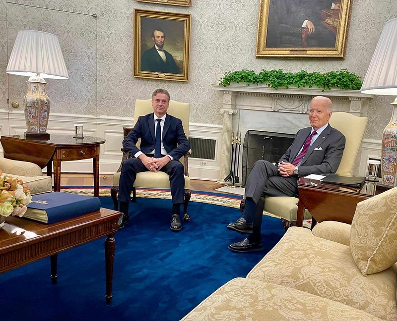 The two presidents sit in armchairs by the fireplace