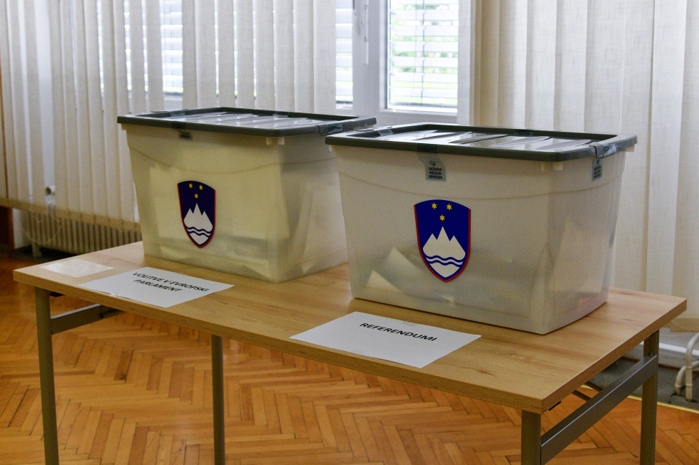 Two ballot boxes with a picture of the Slovenian coat of arms.