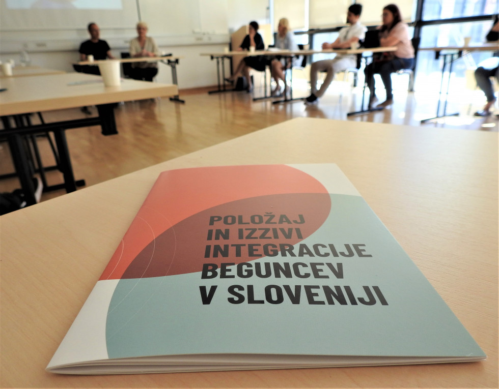 Na mizi brošura o beguncih z naslovom Položaj in izzivi integracije beguncev v Sloveniji